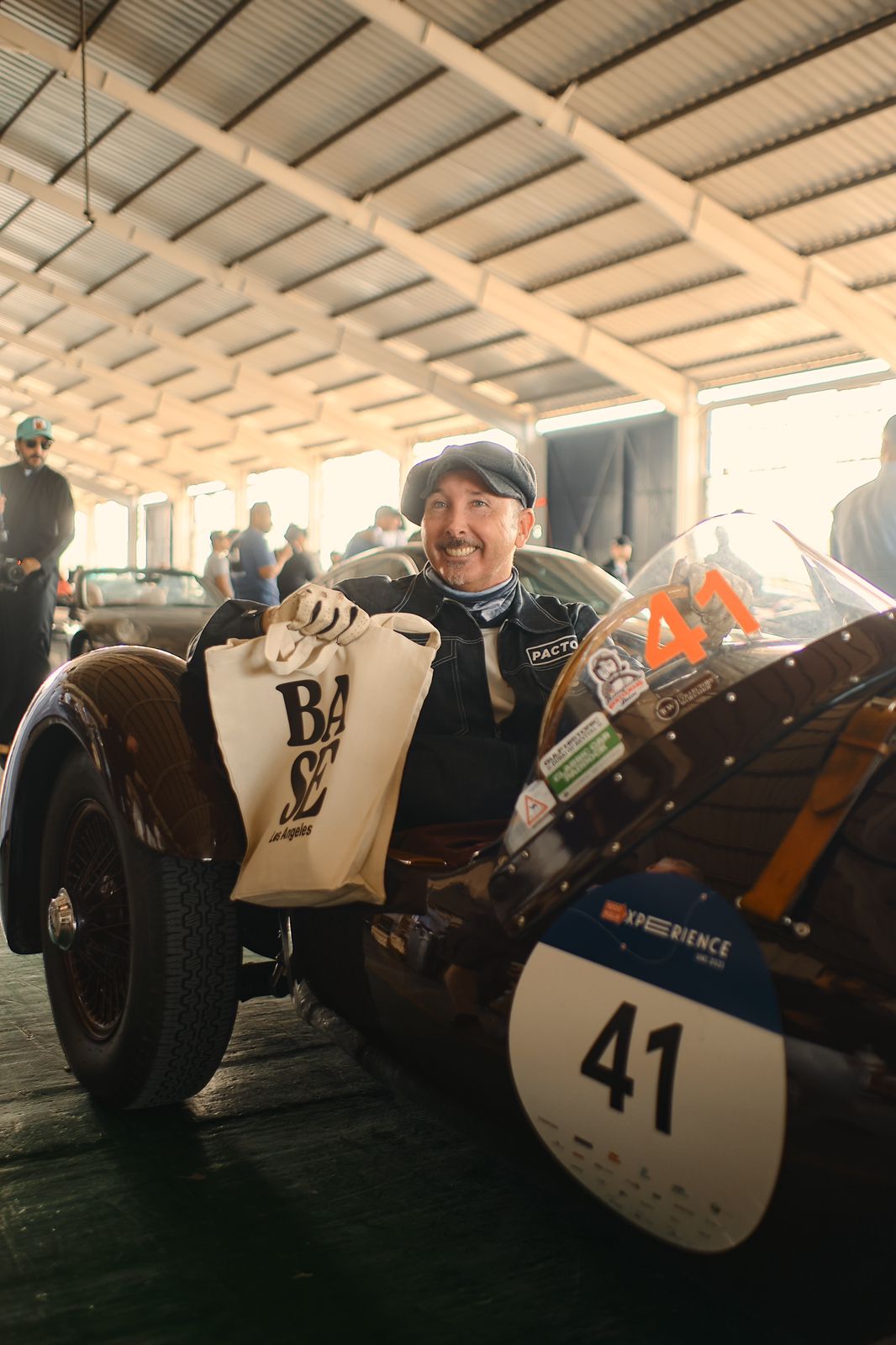 BASE tote held by a vintage race car driver in the paddock